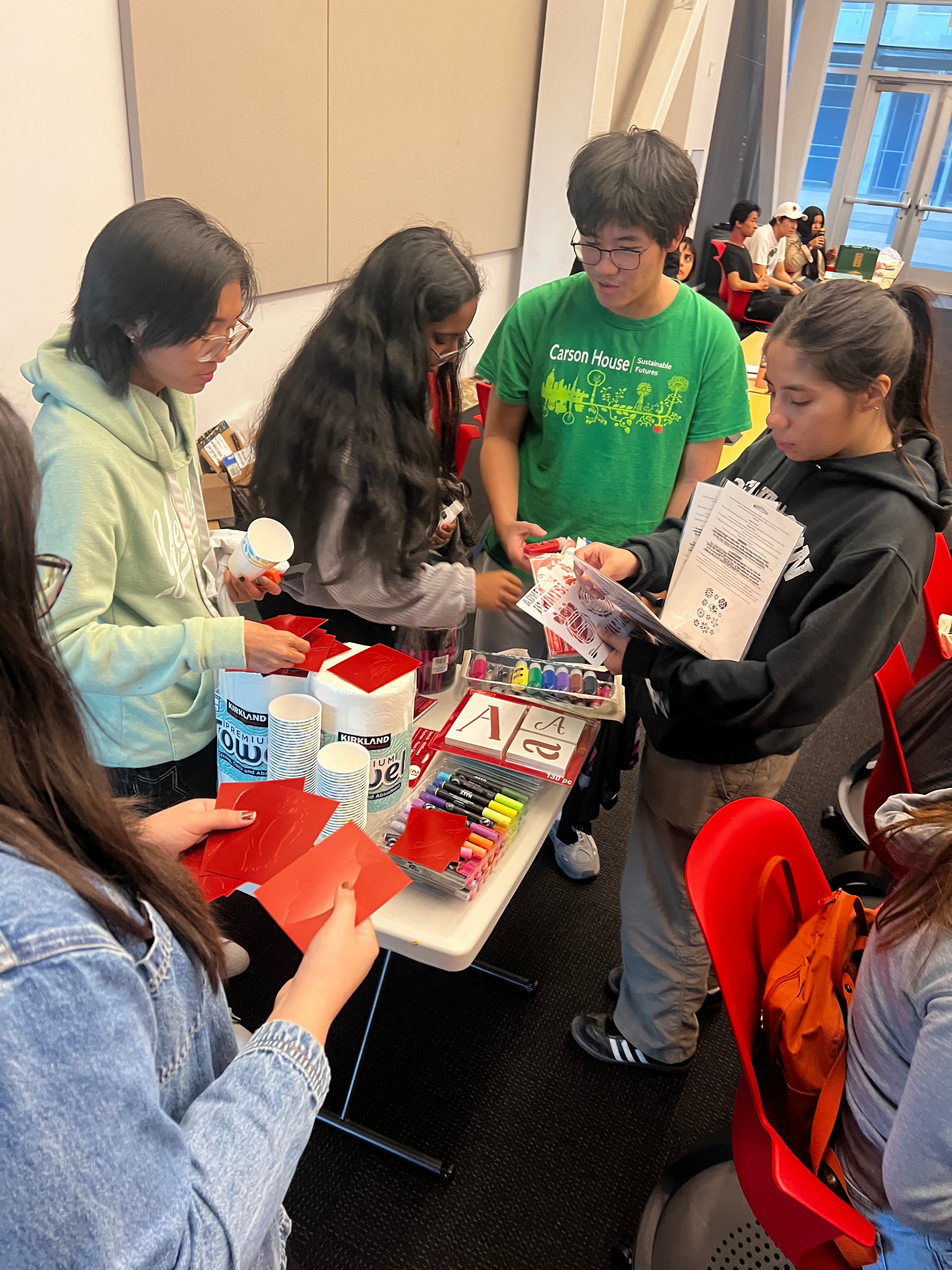 A picture of UC Merced students picking out arts and crafts supplies for use in clothes upcycling